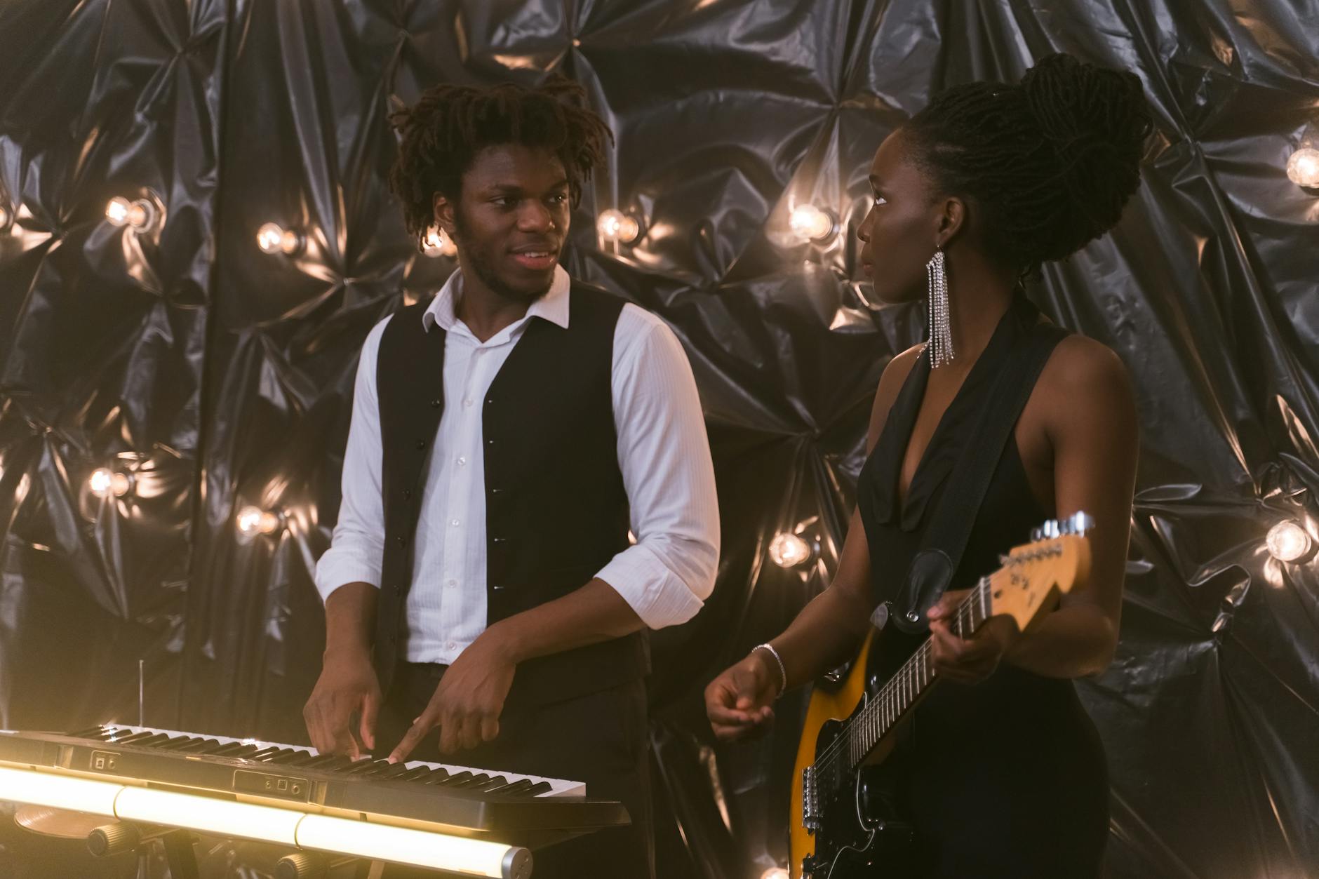 Pianista i gitarzystka grają razem w eleganckim wnętrzu