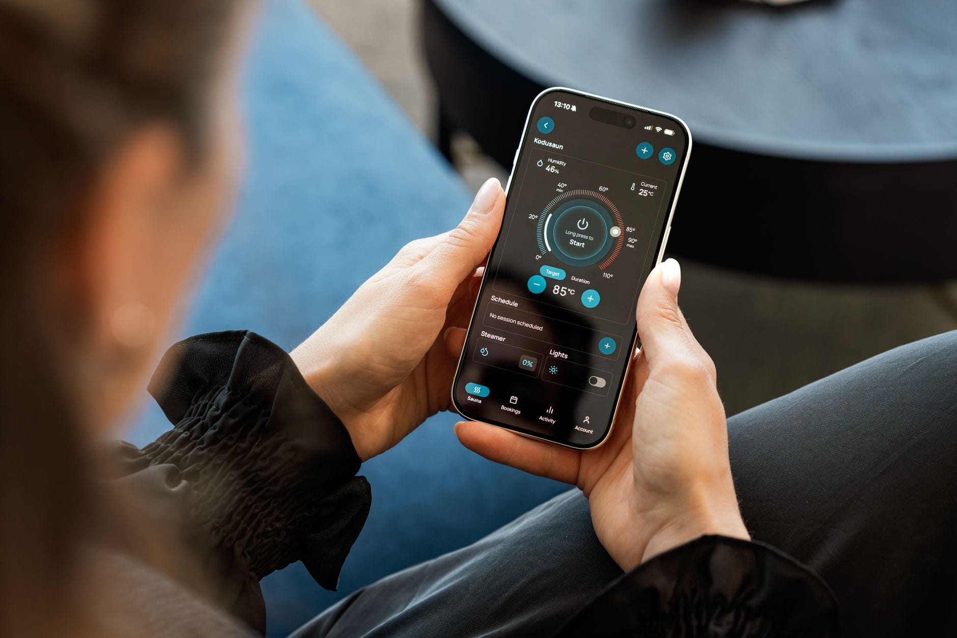 Kobieta steruje ogrzewaniem w domu za pomocą aplikacji w smartfonie