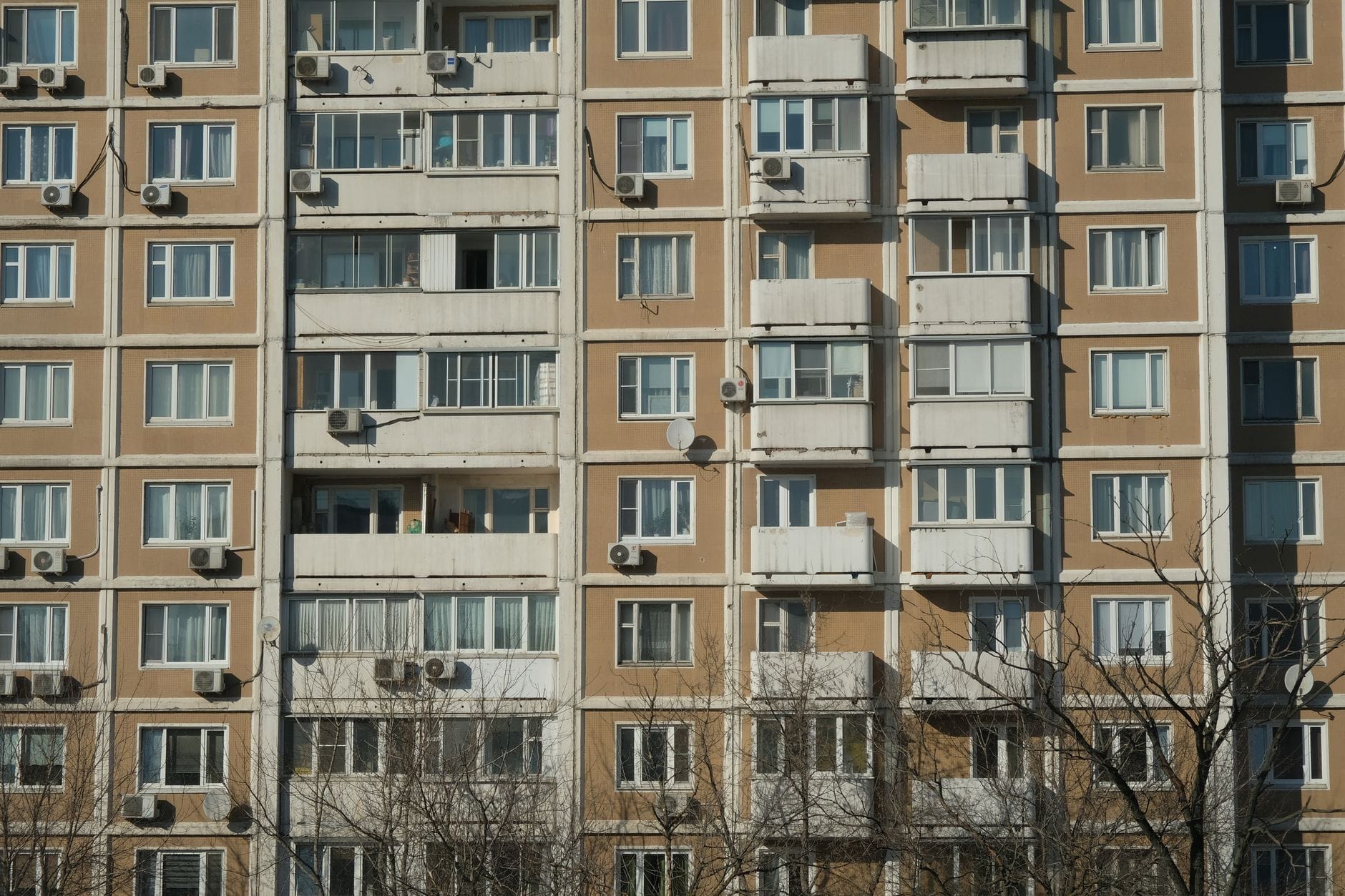 Nasłoneczniona kamienica miejska z balkonami i klimatyzatorami