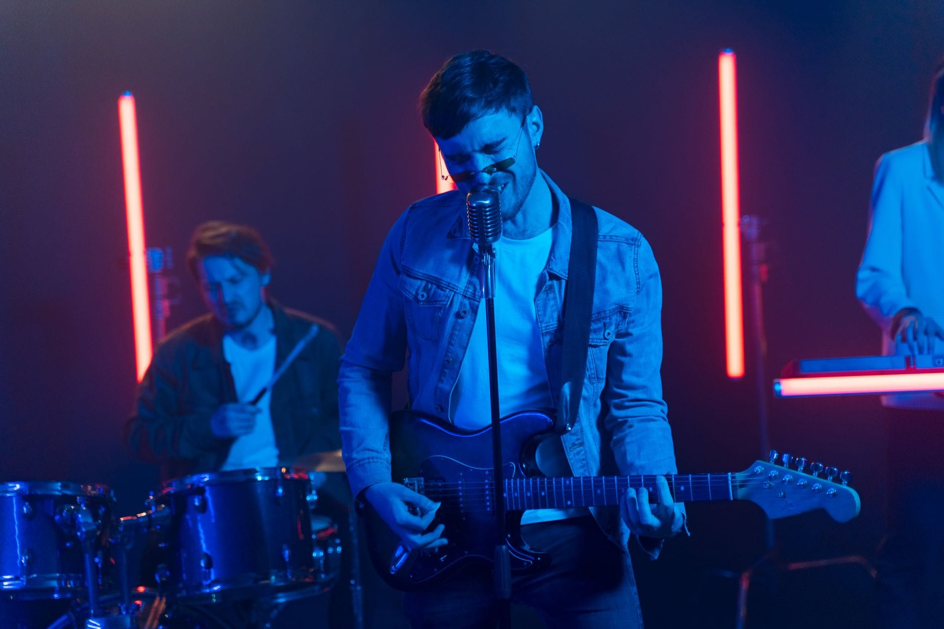 Rockowy zespół gra na scenie w neonowych światłach